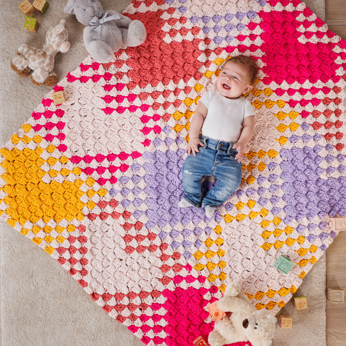 With All My Heart Crochet Blanket made using Bernat yarn in a styled lifestyle setting