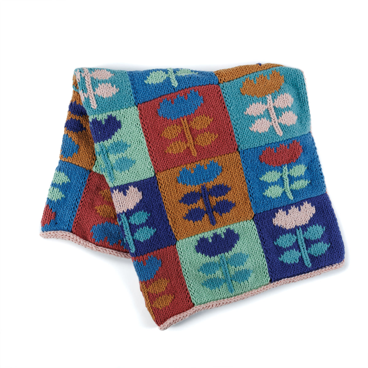 Meadow Mosaic Knit Blanket made using Bernat yarn in a styled lifestyle setting