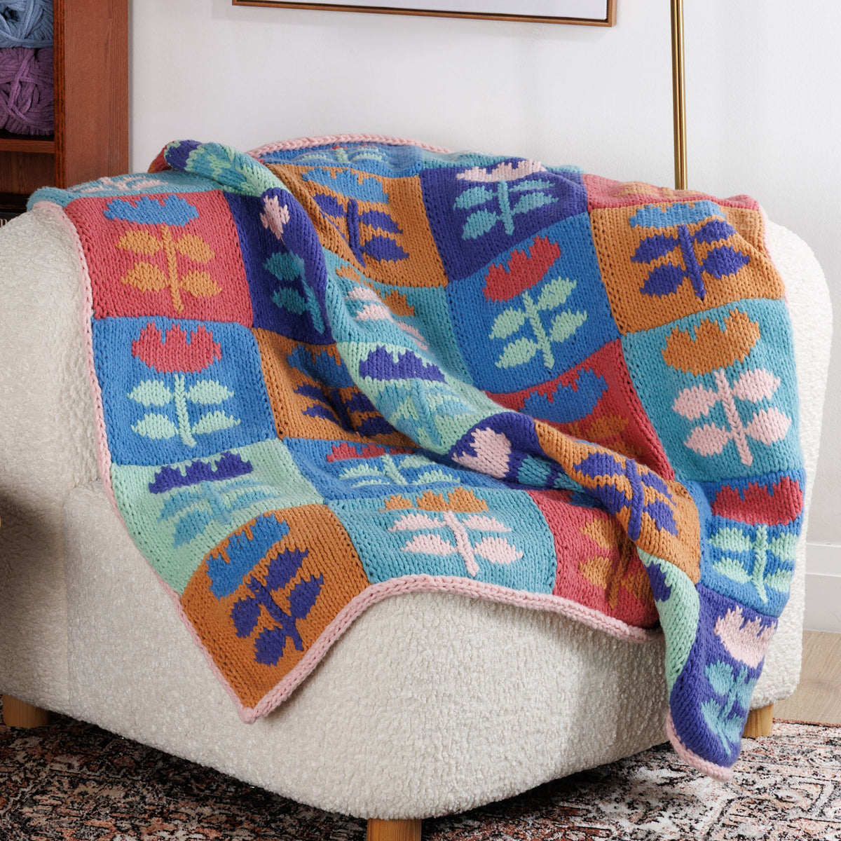 Meadow Mosaic Knit Blanket made using Bernat yarn in a styled lifestyle setting