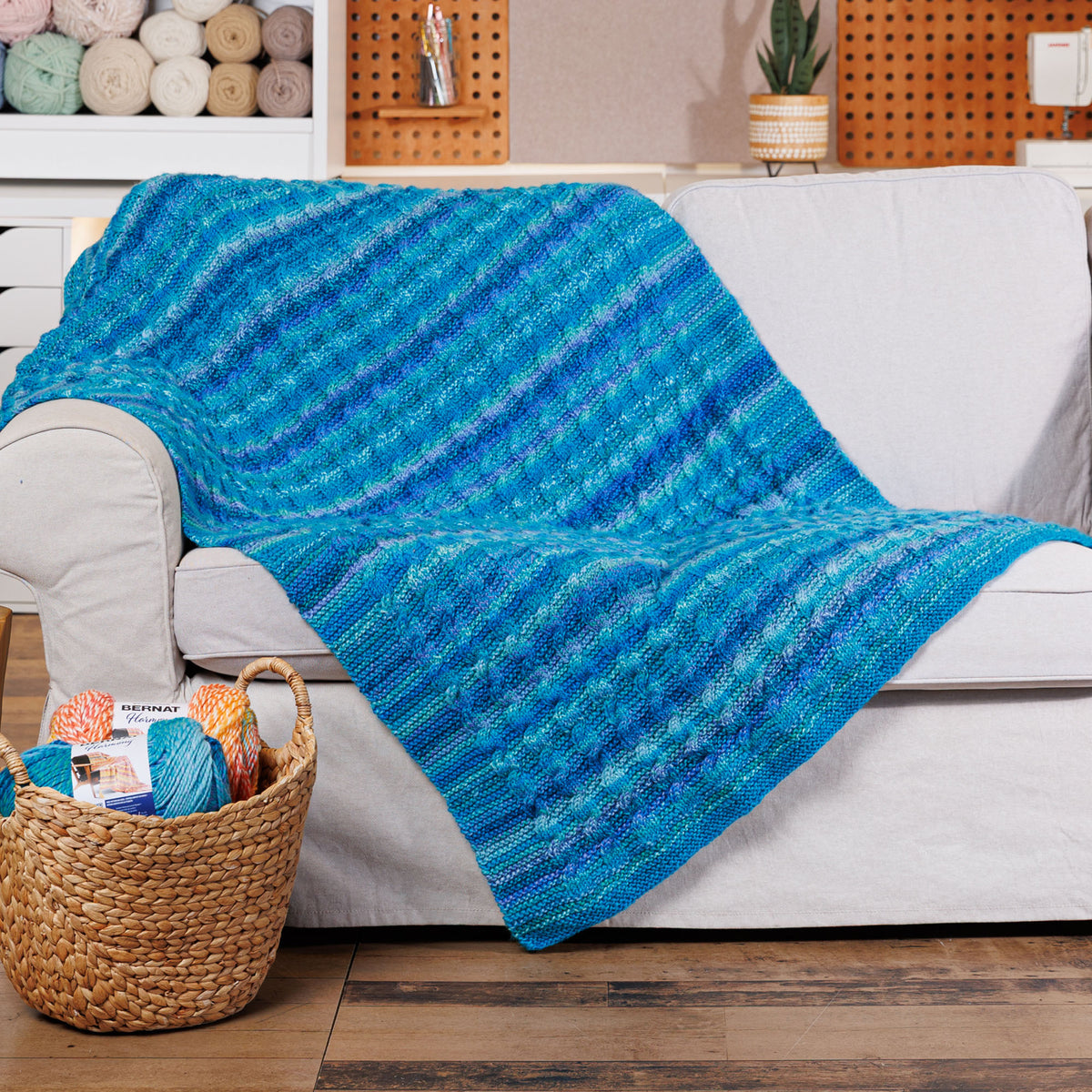 Knit Classic Cables Throw made using Bernat yarn in a styled lifestyle setting
