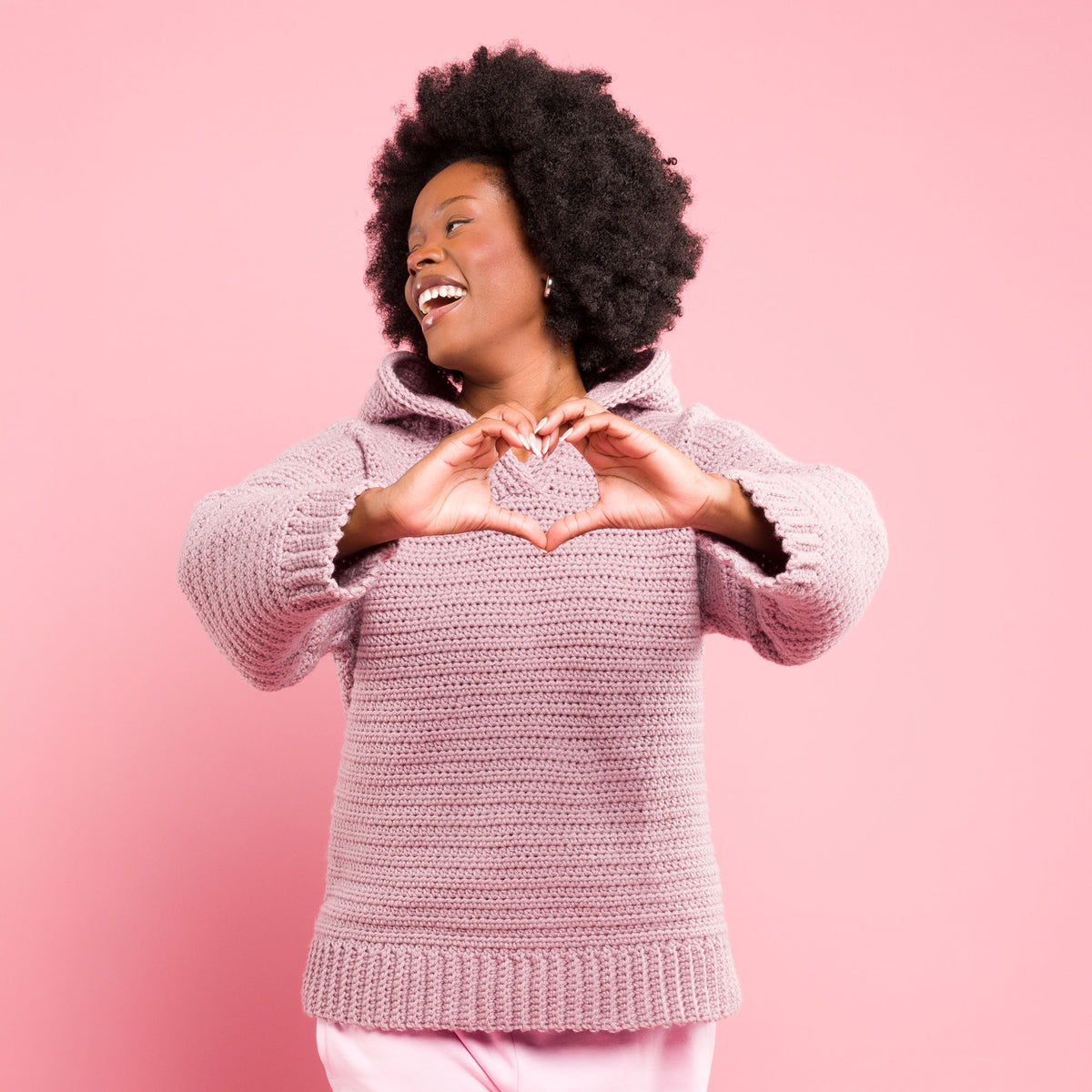 Shimmering Phrase On Crochet Pullover made using Caron yarn in a styled lifestyle setting