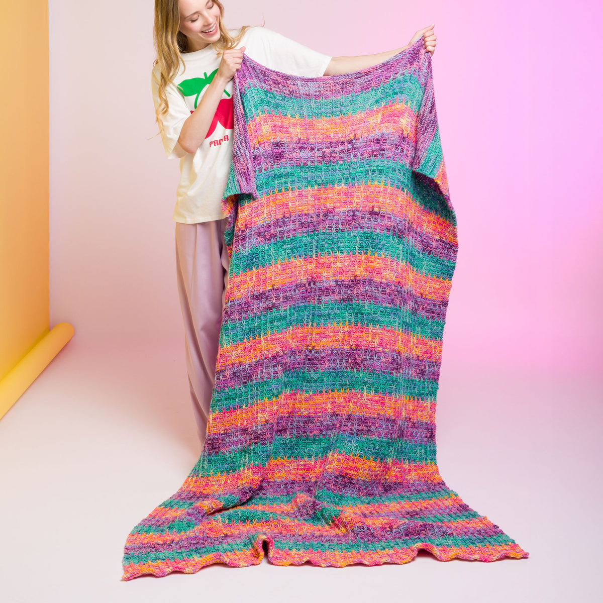 Slipstream Knit Blanket made using Caron yarn in a styled lifestyle setting