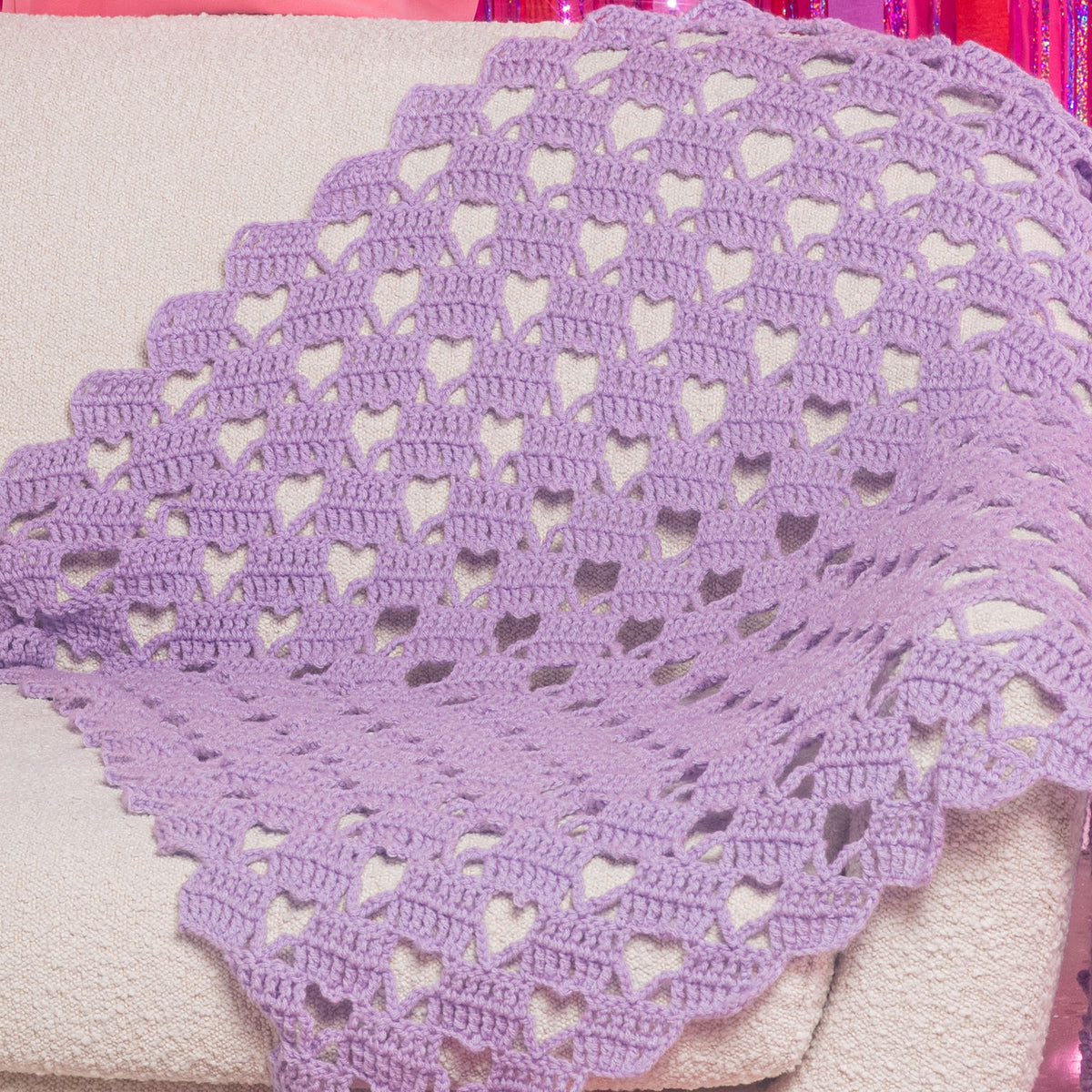 Crochet Heart-Y Lace Blanket made using Red Heart yarn in a styled lifestyle setting