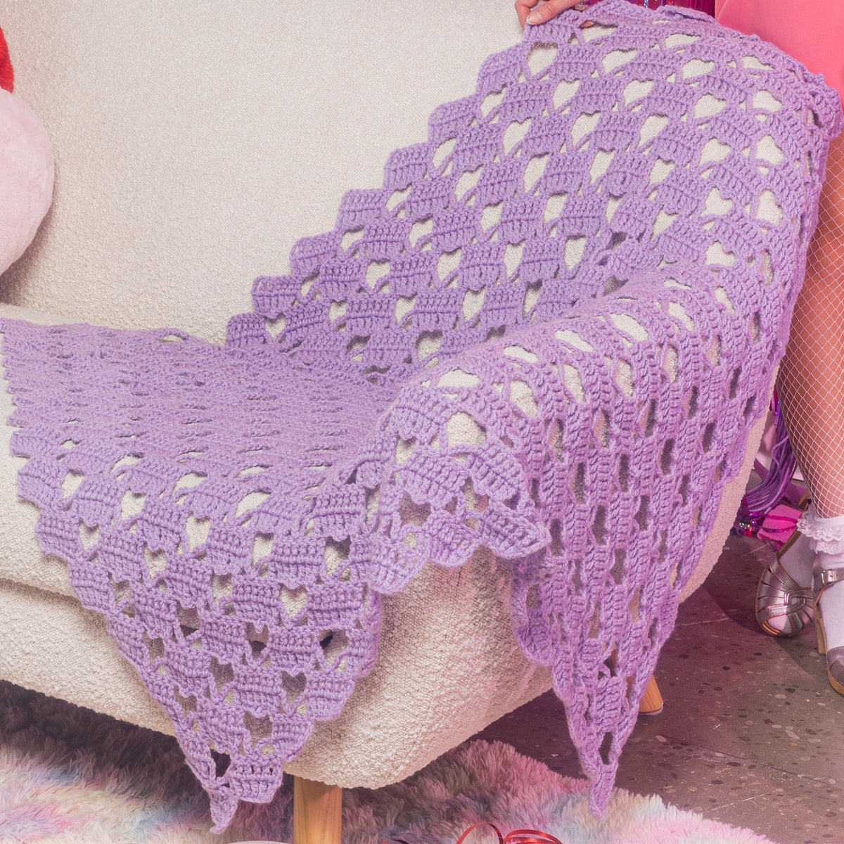 Crochet Heart-Y Lace Blanket made using Red Heart yarn in a styled lifestyle setting