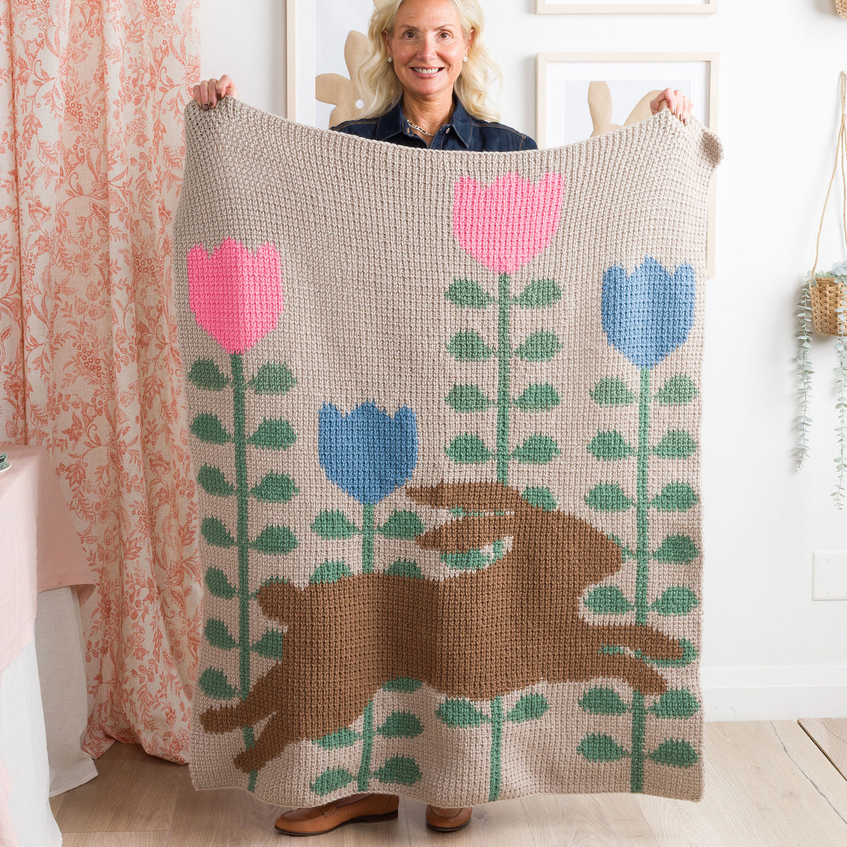 Leaping Into Spring Crochet Blanket made using Red Heart yarn in a styled lifestyle setting