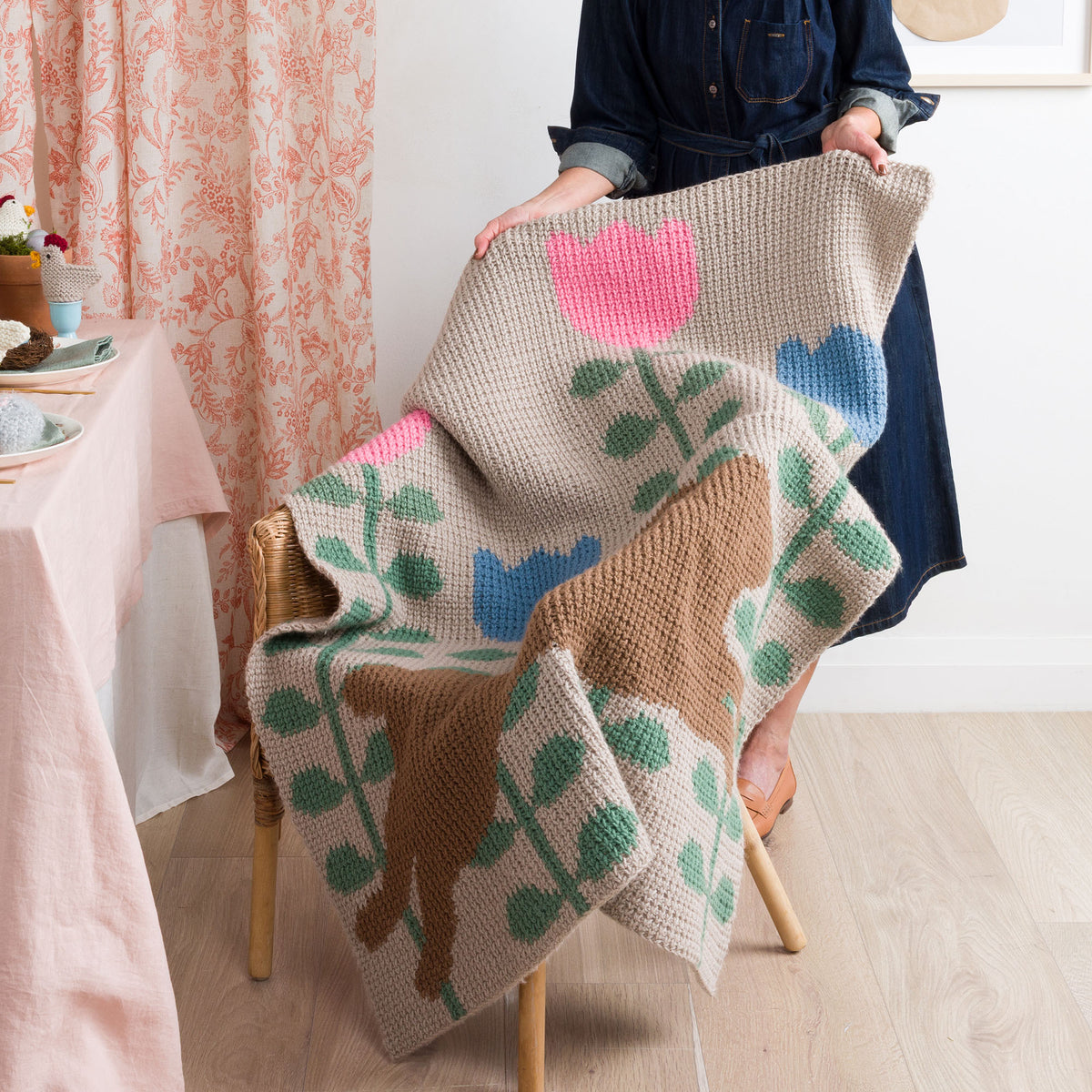 Leaping Into Spring Crochet Blanket made using Red Heart yarn in a styled lifestyle setting
