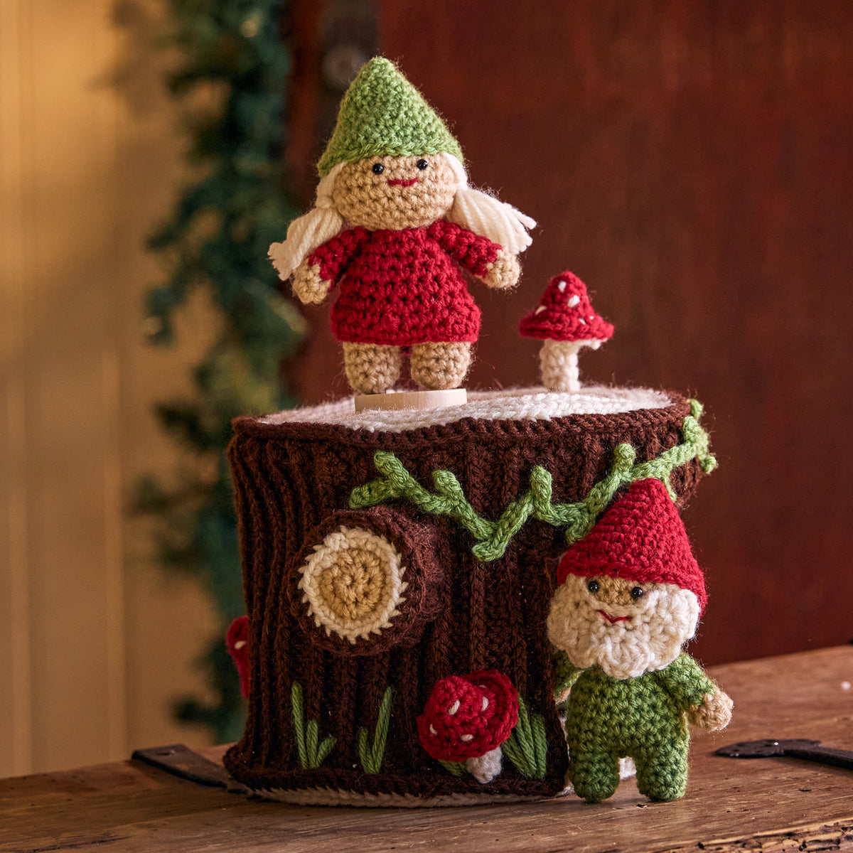 Crochet Gnomes With A Little Stump House made using Red Heart yarn in a styled lifestyle setting