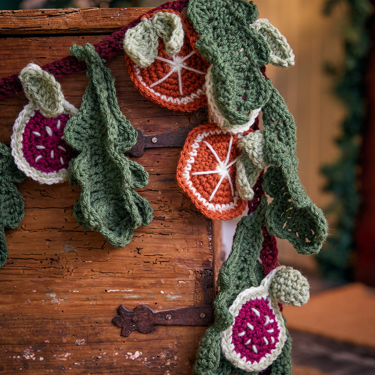 Festive Abundance Crochet Garland made using Red Heart yarn in a styled lifestyle setting