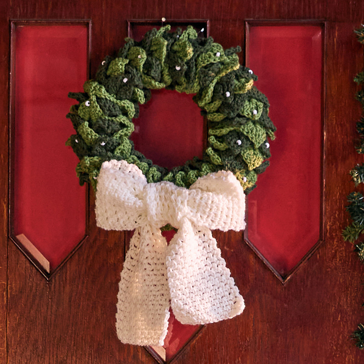 Crochet Berry Cute Wreath made using Red Heart yarn in a styled lifestyle setting