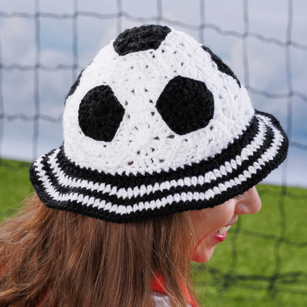Crochet Soccer Ball Hat made using Red Heart yarn in a styled lifestyle setting