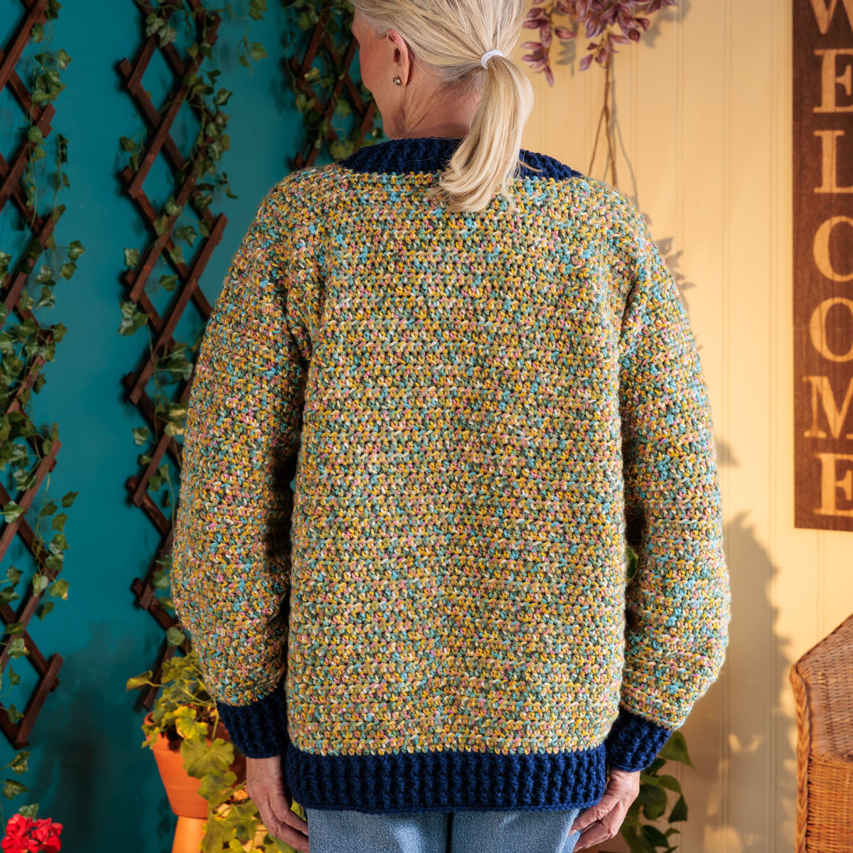 Getting Cozy Crochet Pullover made using Red Heart yarn in a styled lifestyle setting