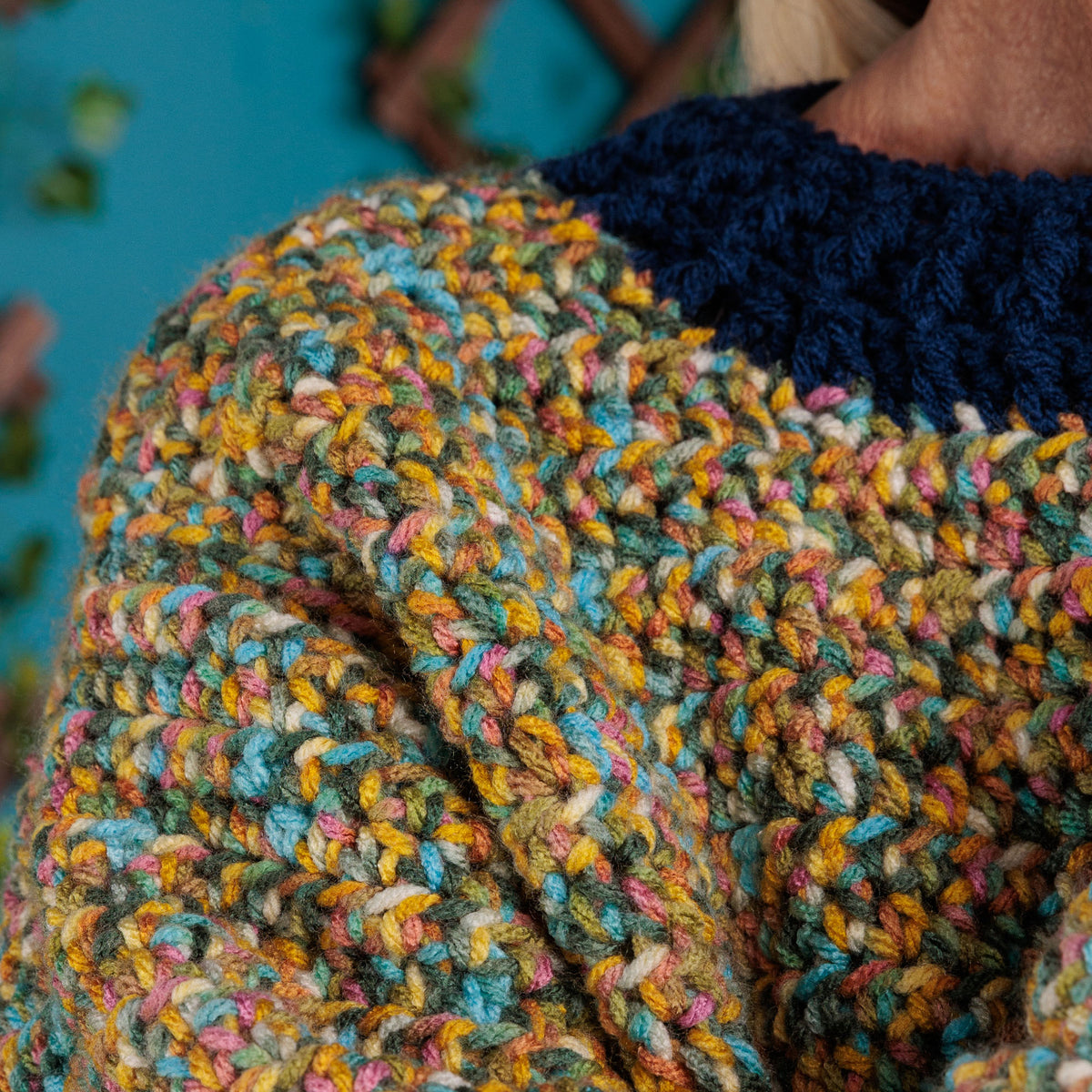 Getting Cozy Crochet Pullover made using Red Heart yarn in a styled lifestyle setting