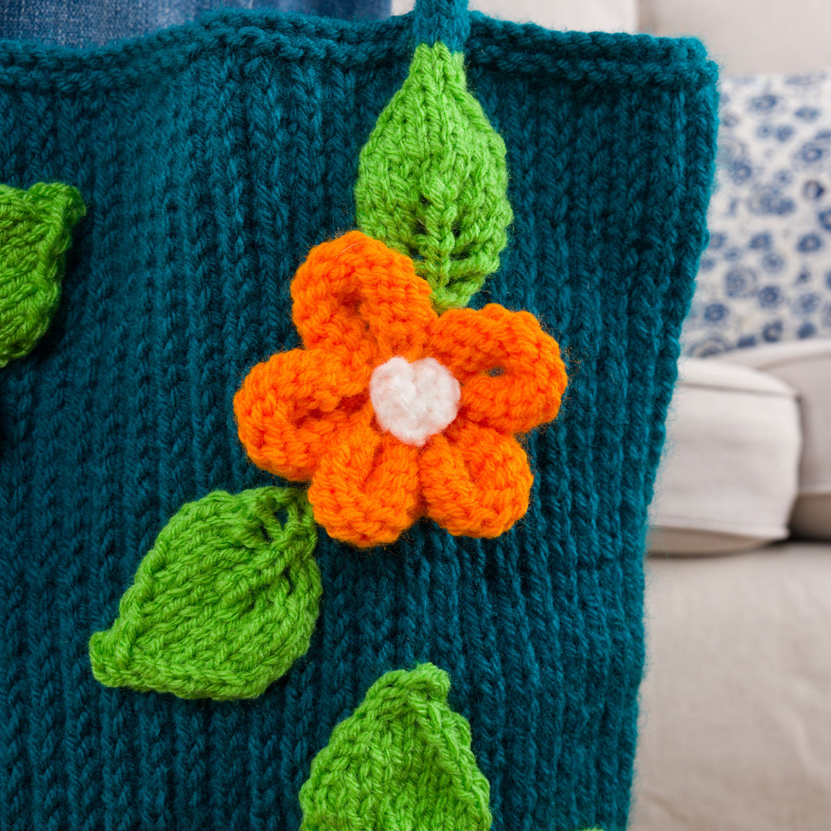 Knit Floral Tote made using Red Heart yarn in a styled lifestyle setting
