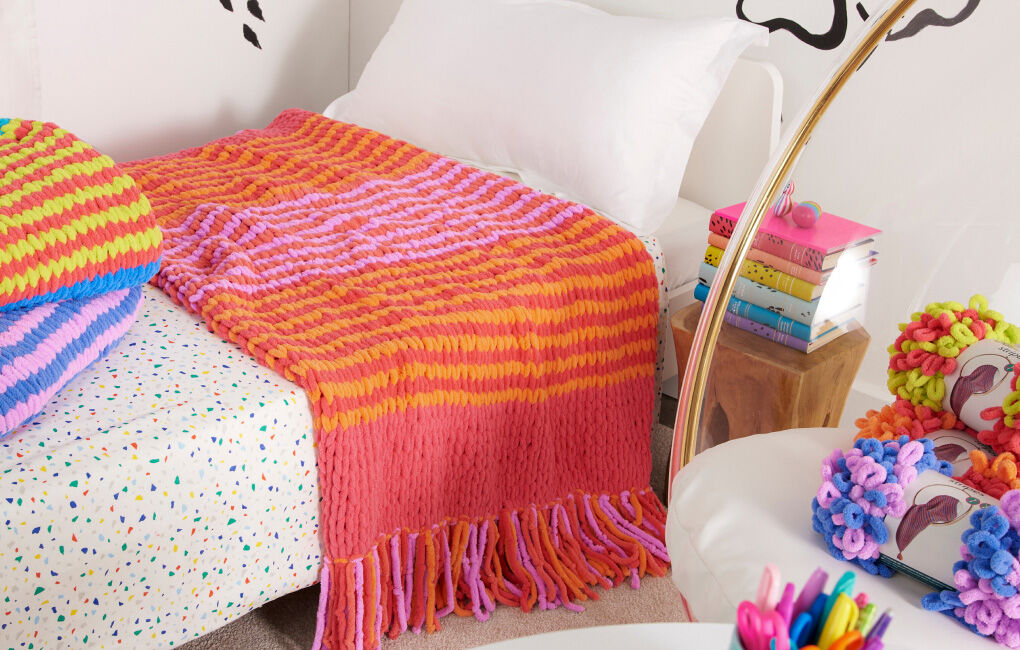 Colorful EZ Stripe blankets draped on couch