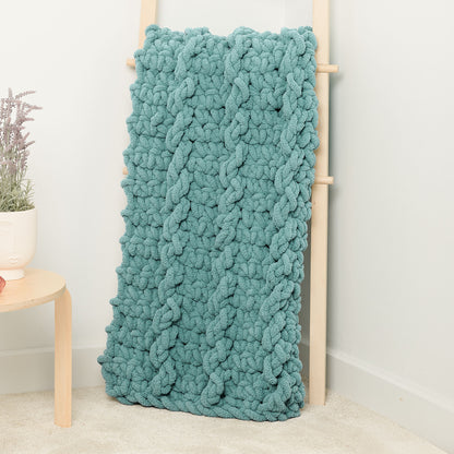 Bernat Big Mood Mock Cable Crochet Blanket Big Mood Mock Cable Crochet Blanket made using Bernat yarn in a styled lifestyle setting