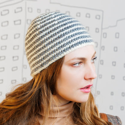 Caron Striped Right Hat Woman wearing a striped crochet hat against a light background