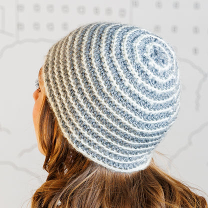 Caron Striped Right Hat Person wearing a striped crochet beanie with a neutral background
