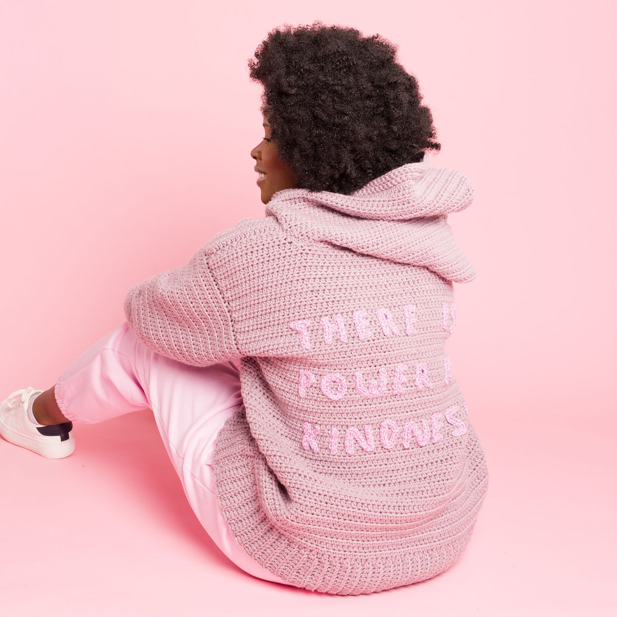 Shimmering Phrase On Crochet Pullover made using Caron yarn in a styled lifestyle setting