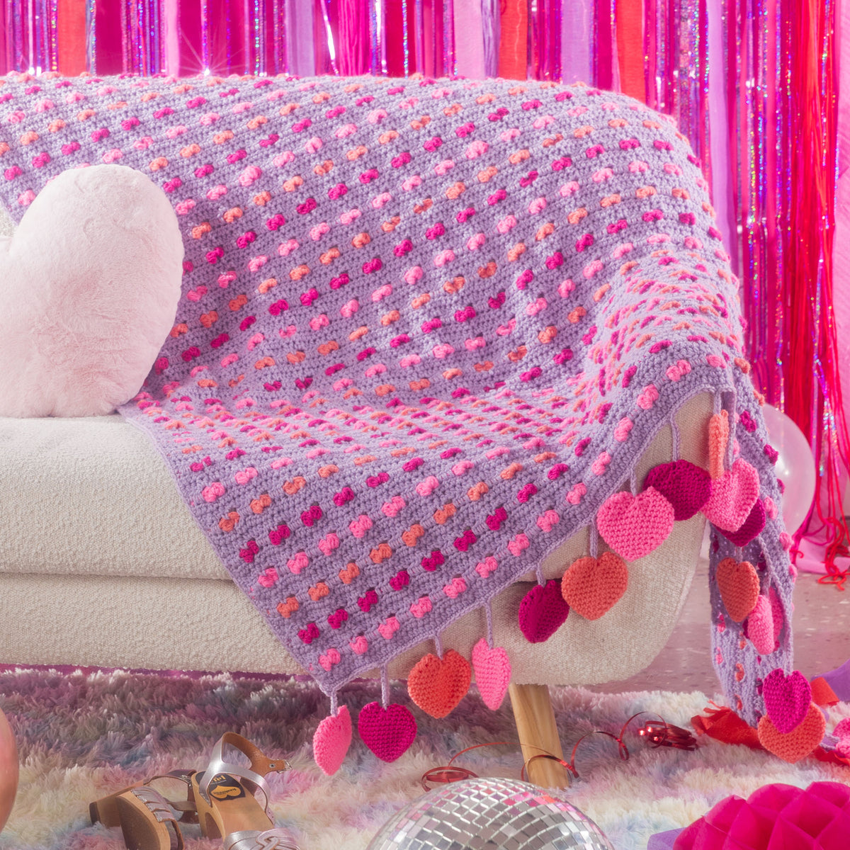 Love Crochet Blanket made using Red Heart yarn in a styled lifestyle setting
