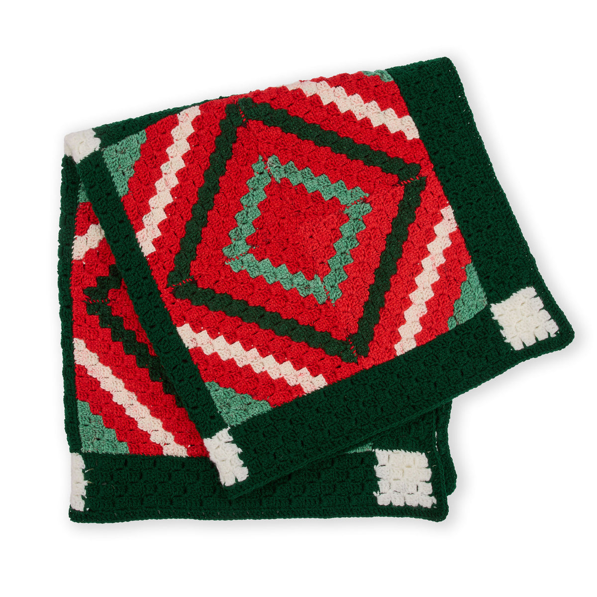 Crochet Quilted Classic Christmas Blanket made using Red Heart yarn in a styled lifestyle setting