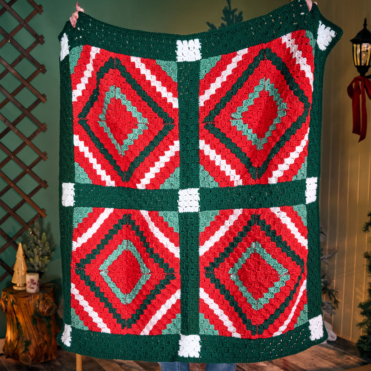 Crochet Quilted Classic Christmas Blanket made using Red Heart yarn in a styled lifestyle setting