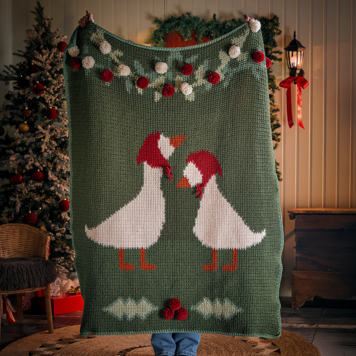 Holiday Geese Crochet Blanket made using Red Heart yarn in a styled lifestyle setting
