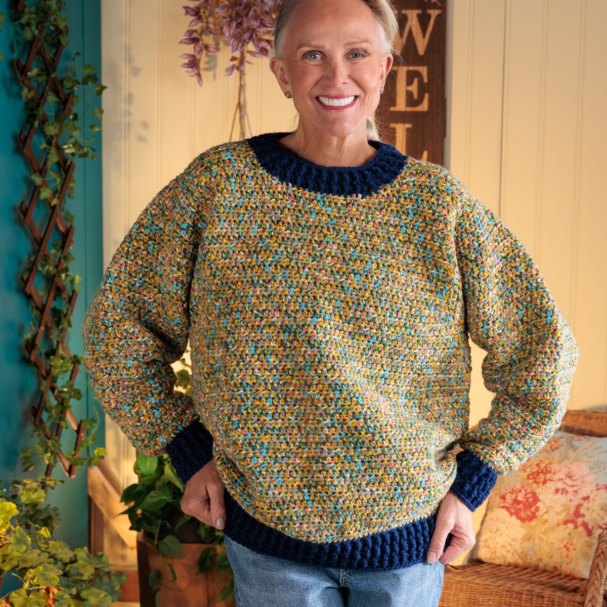 Getting Cozy Crochet Pullover made using Red Heart yarn in a styled lifestyle setting