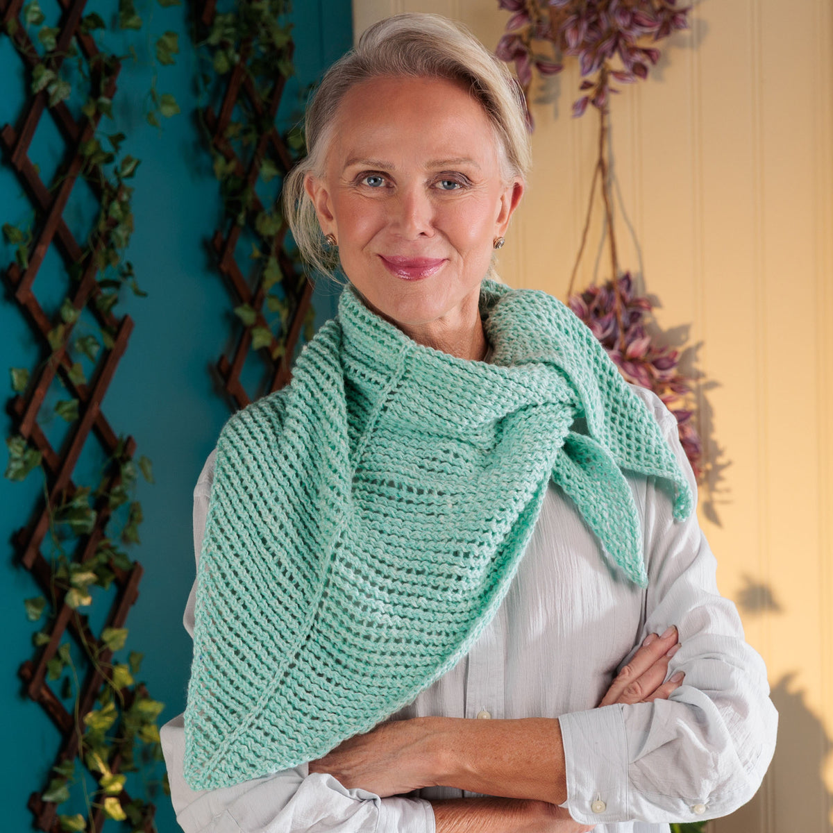 Cool Breeze Knit Shawl made using Red Heart yarn in a styled lifestyle setting