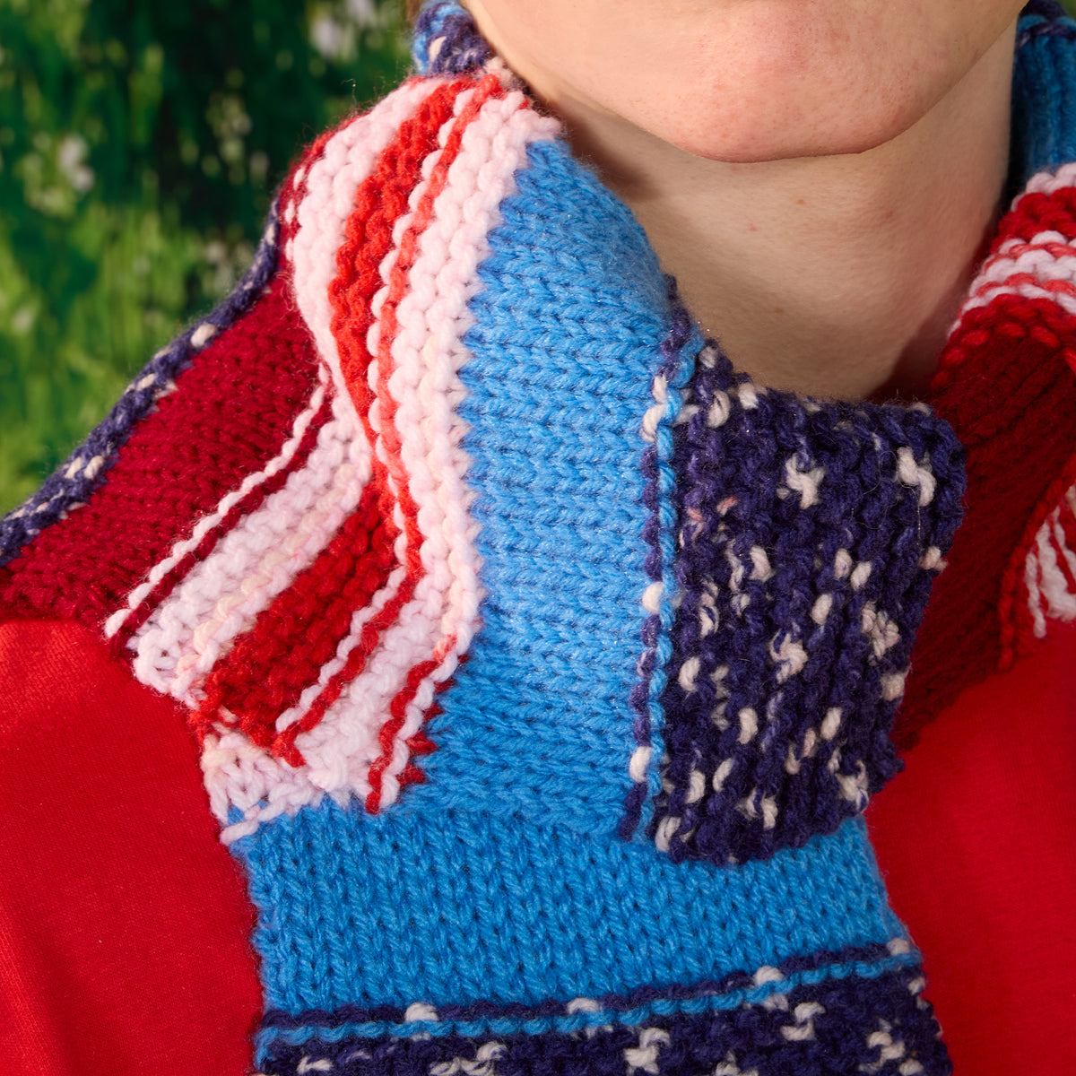 Americana Knit Scarf made using Red Heart yarn in a styled lifestyle setting