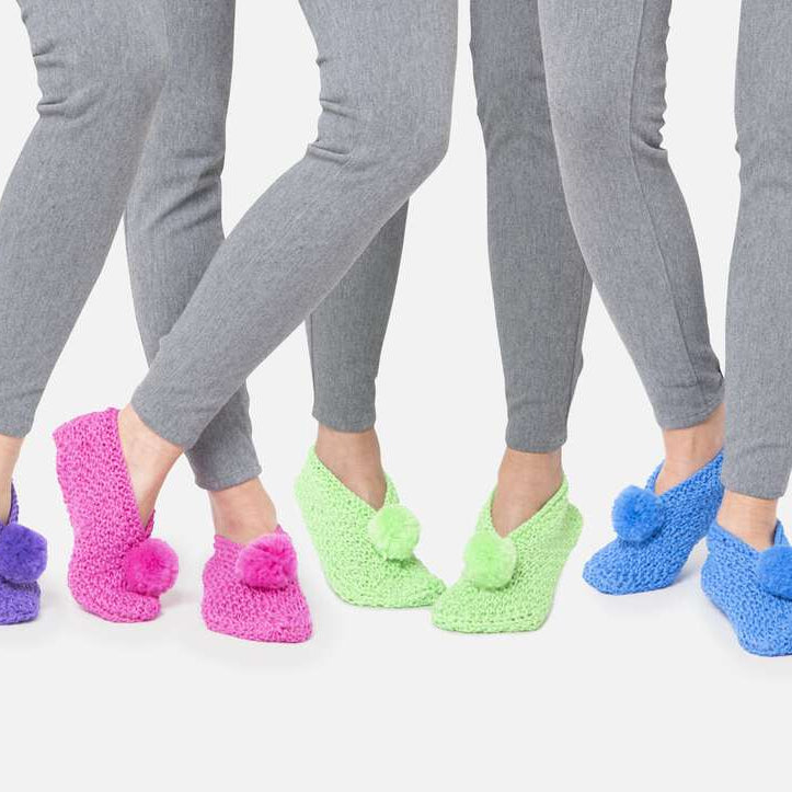 models wearing crochet slippers with pom pom in different colors